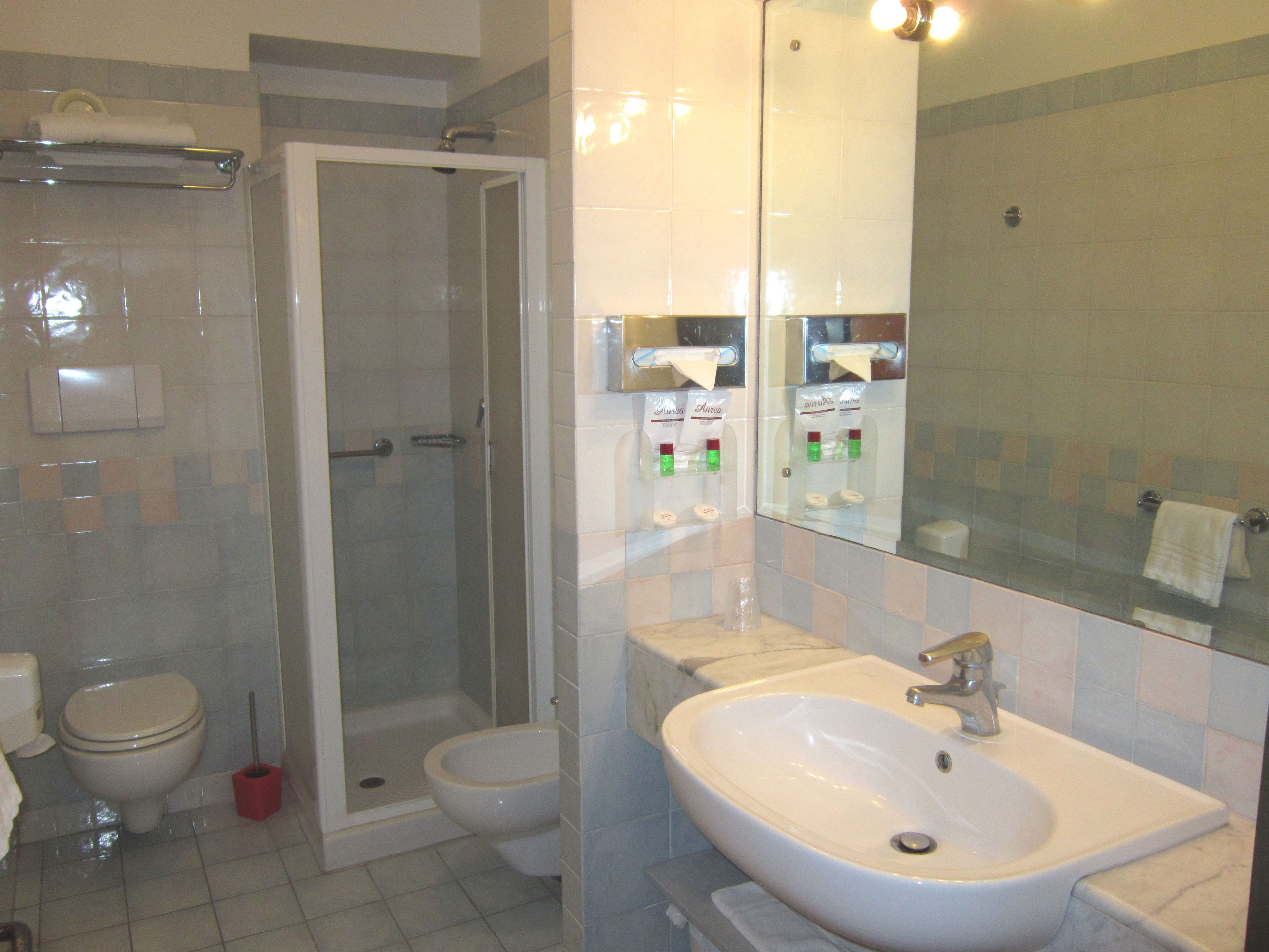 A bathroom with a shower, toilet, and sink.