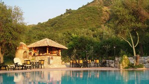 Un área de piscina con un bar y sillones reclinables.