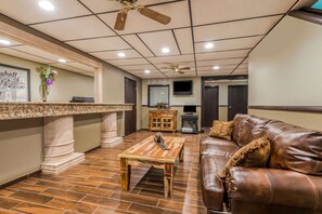 Relax in a welcoming space with a comfortable sofa, coffee table, and TV, surrounded by elegant columns and artwork.