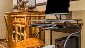 Un bureau en bois avec un écran d’ordinateur, un clavier et une souris.