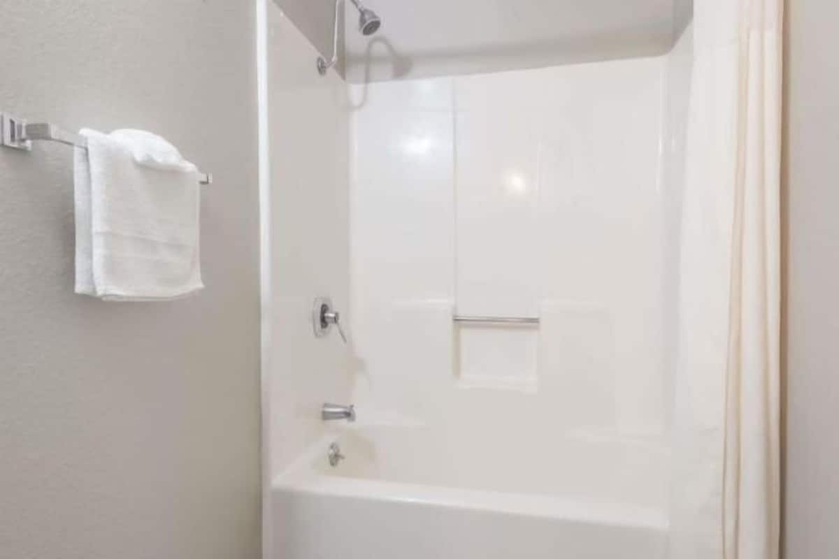 Badkamer | Een bad/douchecombinatie, een diep bad, gratis toiletartikelen