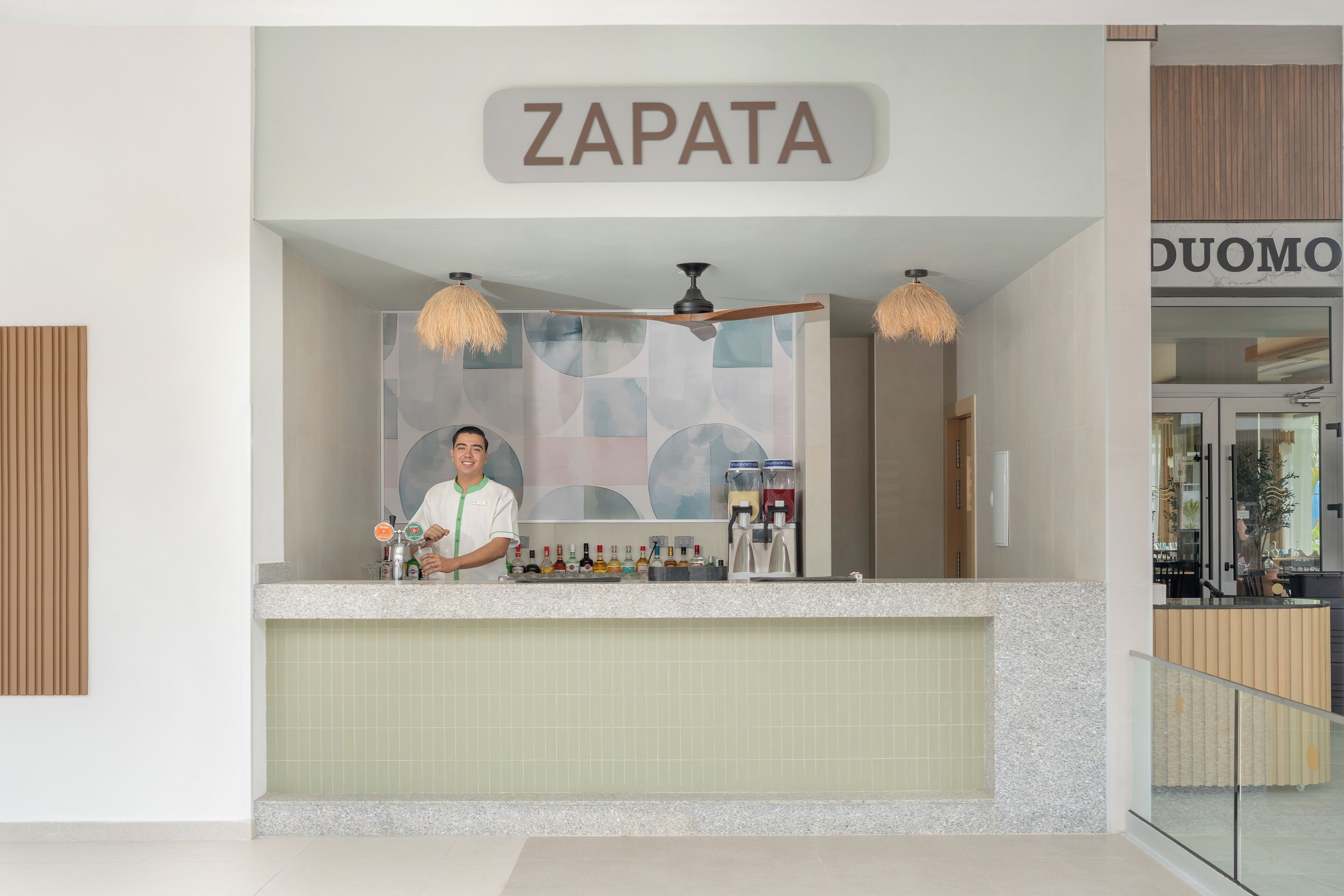 Un área de recepción con un letrero que dice "ZAPATA" sobre un mostrador.