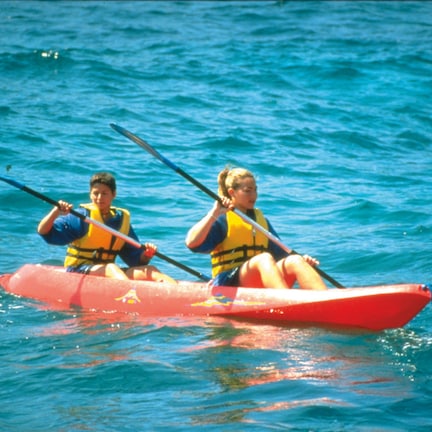 Two people in a red kayak on a body of water.