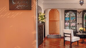 A reception area with a sign reading 'Oriental Spa,' a decorative vase with flowers, a chair, and a tiled floor. - Es Saadi Marrakech Resort Hotel (Marrakech)