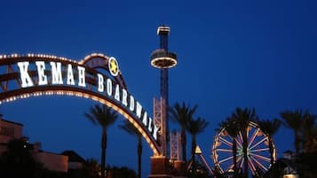 A sign with "KEMAH BOARDWALK" written on it, a Ferris wheel, and a tall tower structure.