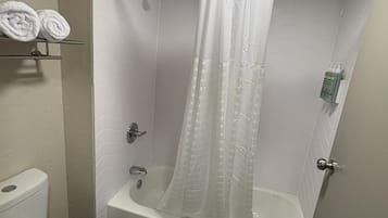 Ein Badezimmer mit Badewanne, Toilette und Duschvorhang.