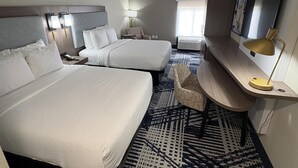 A hotel room with two beds, a desk with a lamp, a chair, a patterned rug, and a large window. - Best Western Spartanburg I-26 (Spartanburg)
