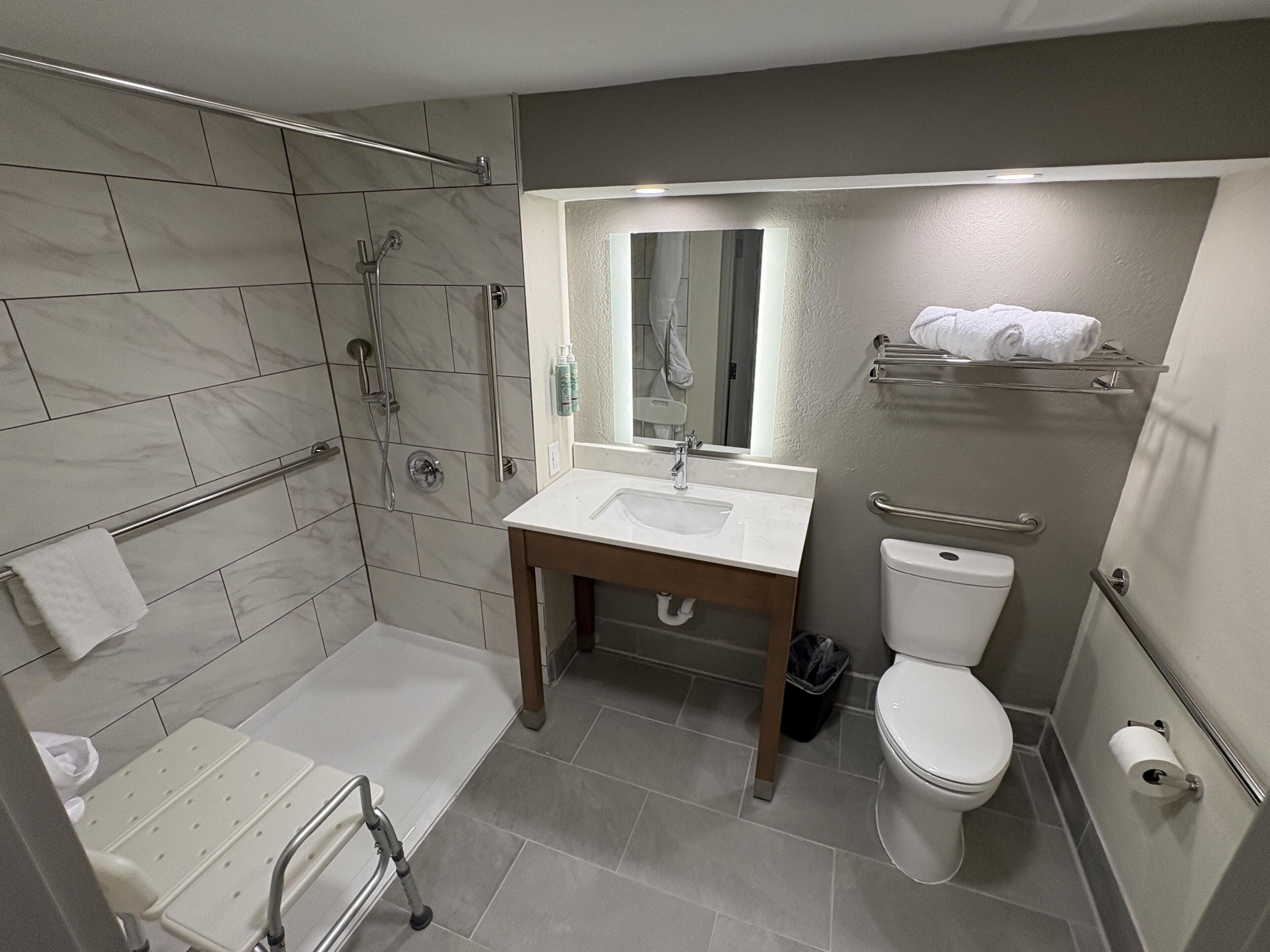 A bathroom with a shower, toilet, and sink.