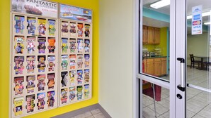 A wall with a bulletin board displaying various travel magazines and a sign above it. - Americas Best Value Inn Seymour (Seymour)