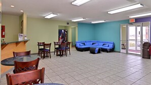 A lobby with a reception desk, seating area, and a blue couch. - Americas Best Value Inn Seymour (Seymour)