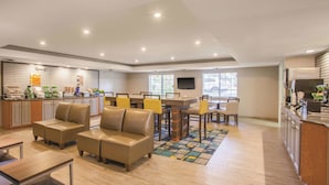 Un amplio espacio habitable con una mesa de comedor, asientos acolchados, una zona de cocina y un televisor.