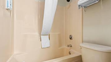Une salle de bain avec une baignoire, des toilettes et un porte-serviettes.