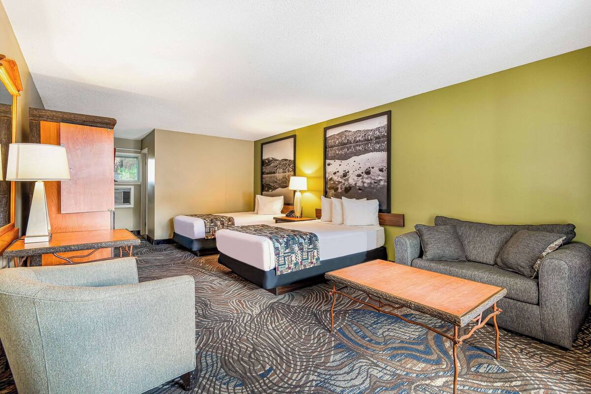 Une chambre d’hôtel avec un lit, un canapé, un bureau et une chaise.