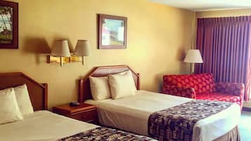 A hotel room with two beds, a nightstand, a lamp, a chair, and a window with curtains.