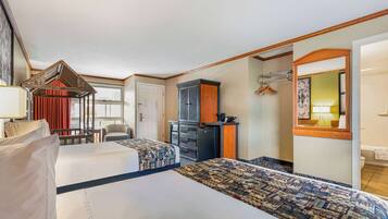A hotel room with two beds, a desk, a dresser, and a mirror.
