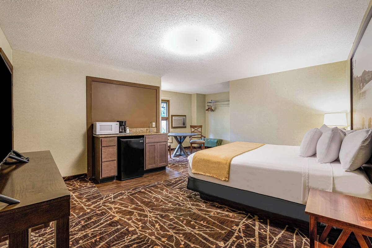 Une chambre d’hôtel équipée d’un lit, d’un bureau, d’un four à micro-ondes, d’une chaise et d’une table.
