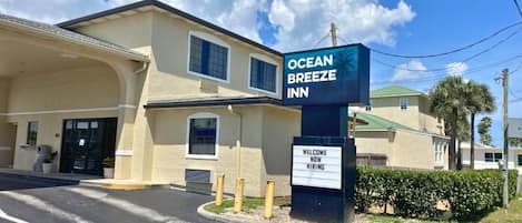 The Ocean Breeze Inn with a sign indicating 'Welcome Now Hiring'.