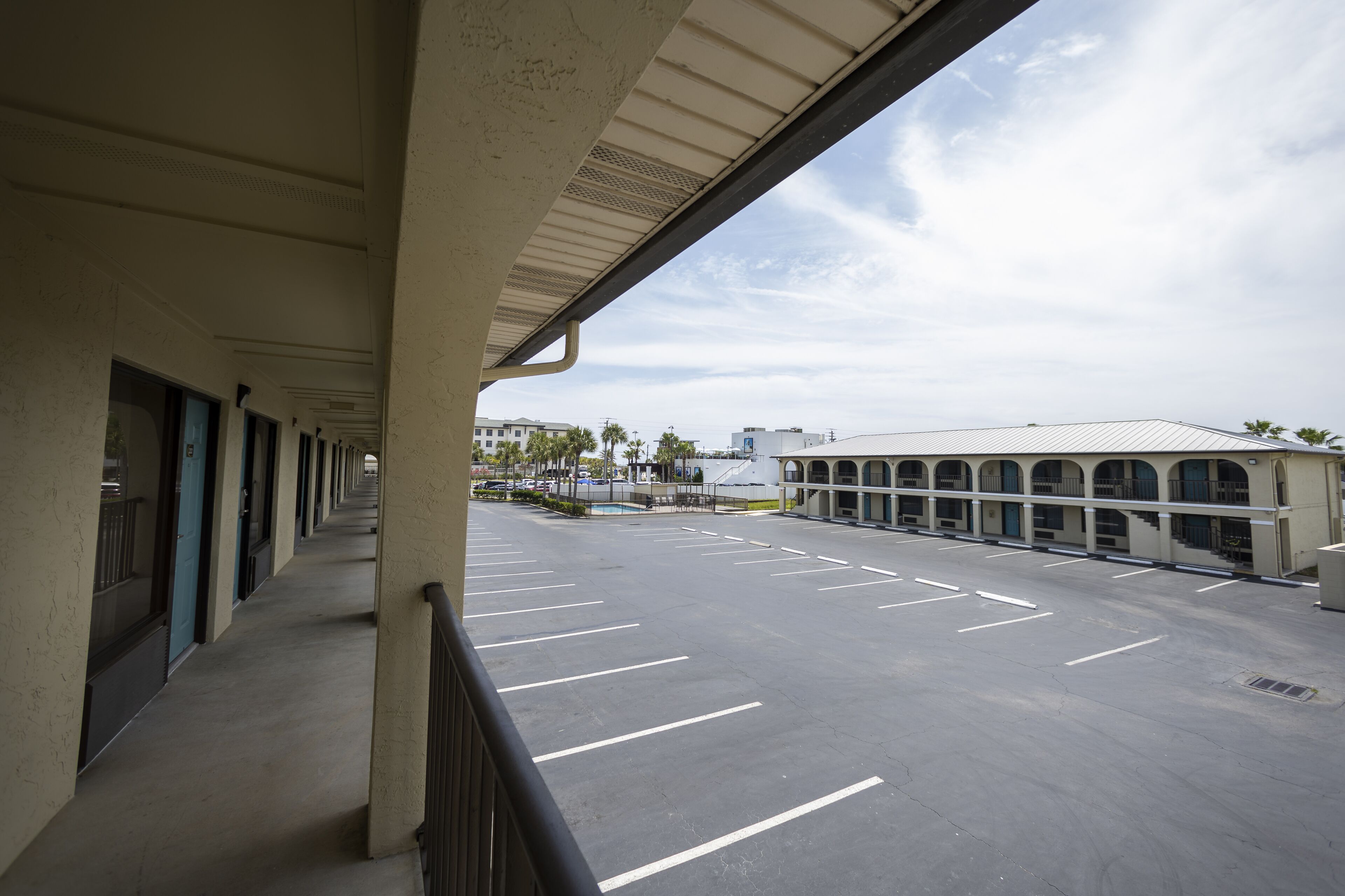 A long corridor with a covered walkway leading to a parking area.