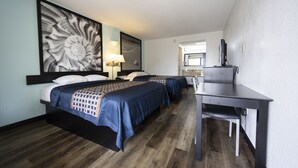 Une chambre d’hôtel avec deux lits, un bureau, une grande œuvre d’art au mur et un miroir.
