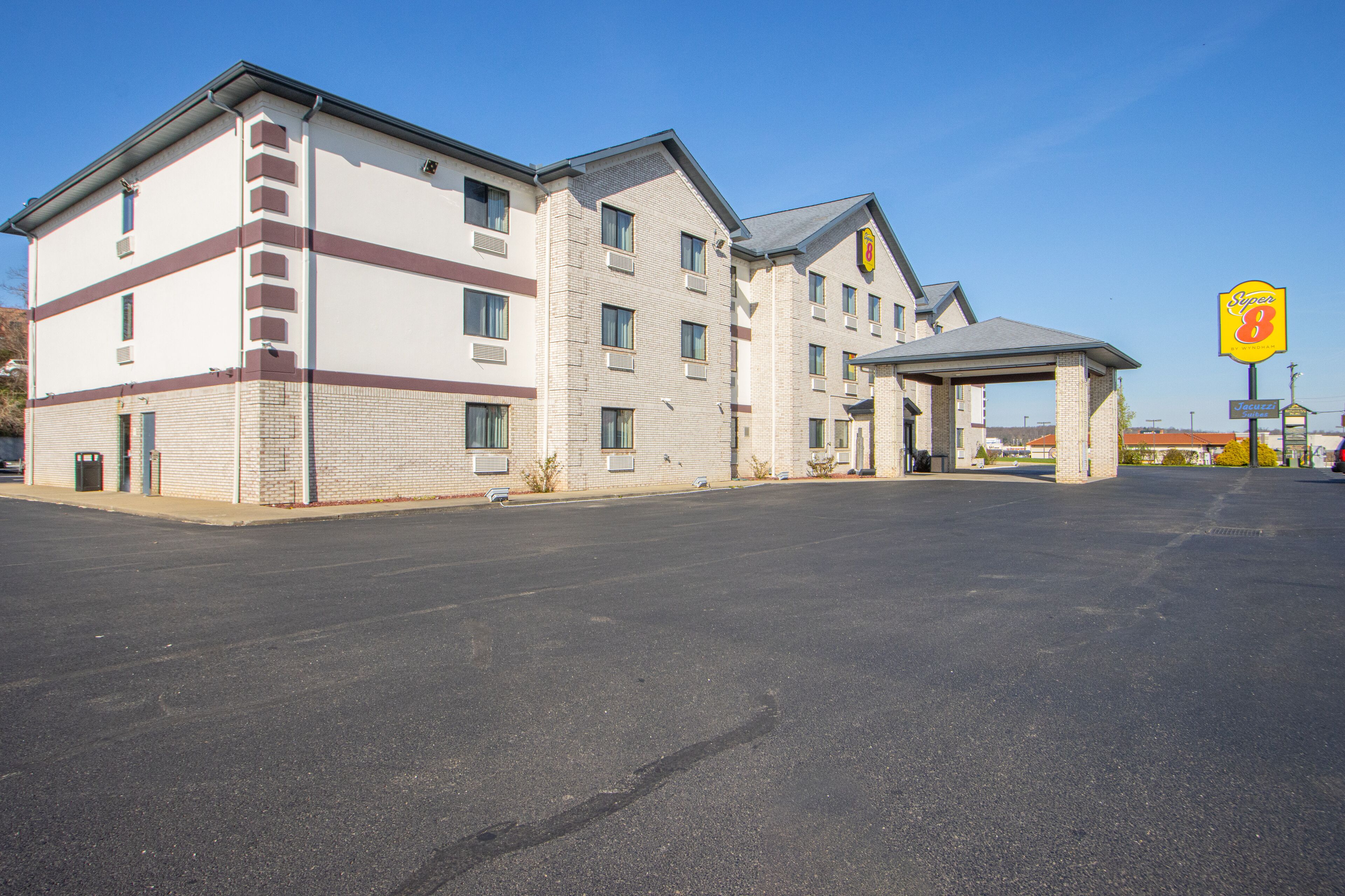 A multi-story hotel with a parking lot in front.