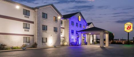 A hotel with a brick facade, a covered entrance, and a 'Super 8' sign.