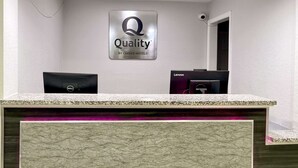Un mostrador de recepción con un cartel que dice "Quality by Choice Hotels".