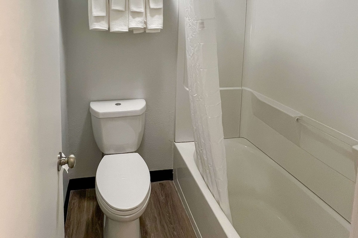 A bathroom with a toilet, a shower, and a bathtub.