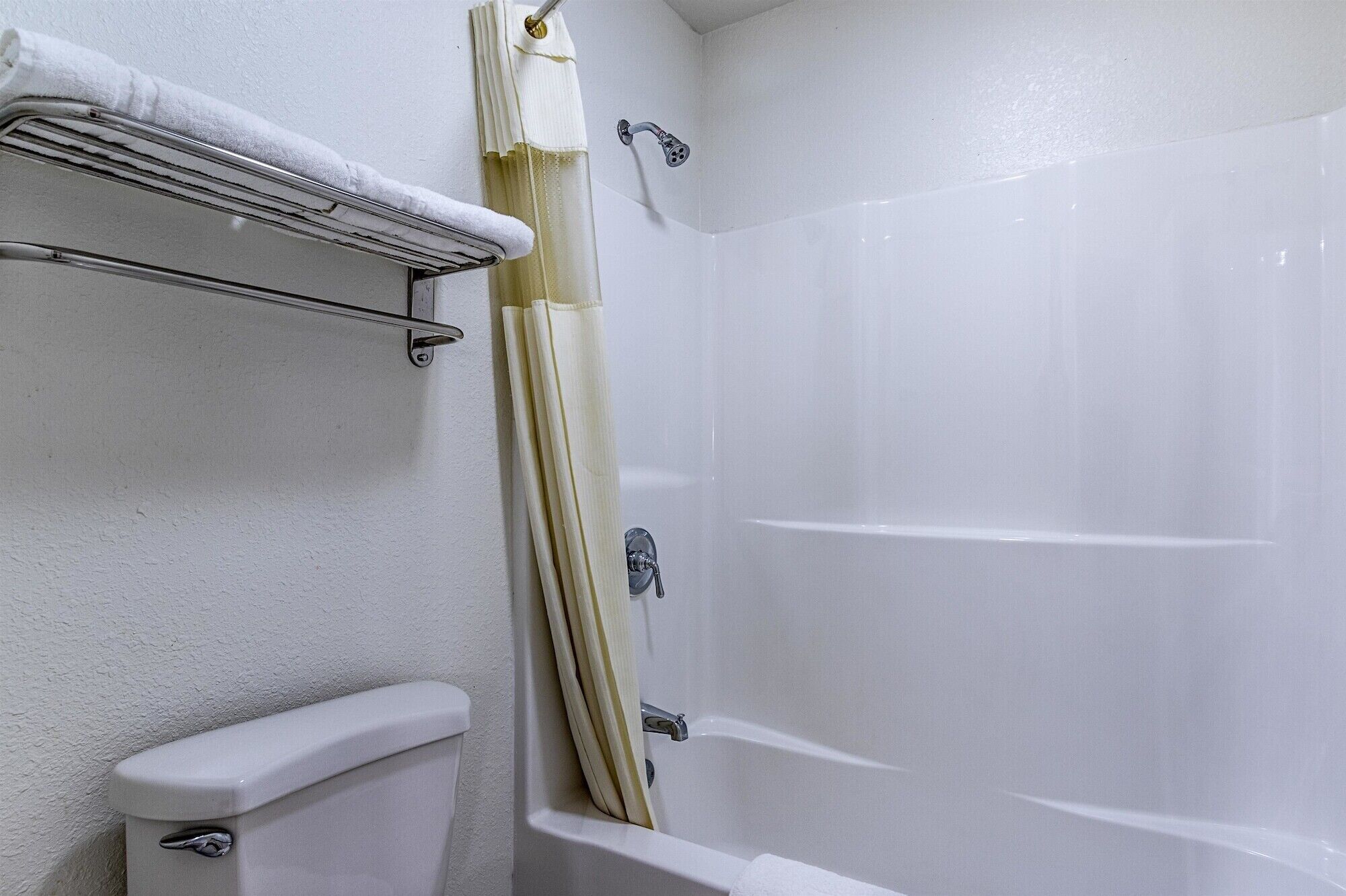 Une salle de bain avec une baignoire, des toilettes et un rideau de douche.