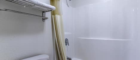 Une salle de bain avec une baignoire, des toilettes et un rideau de douche.