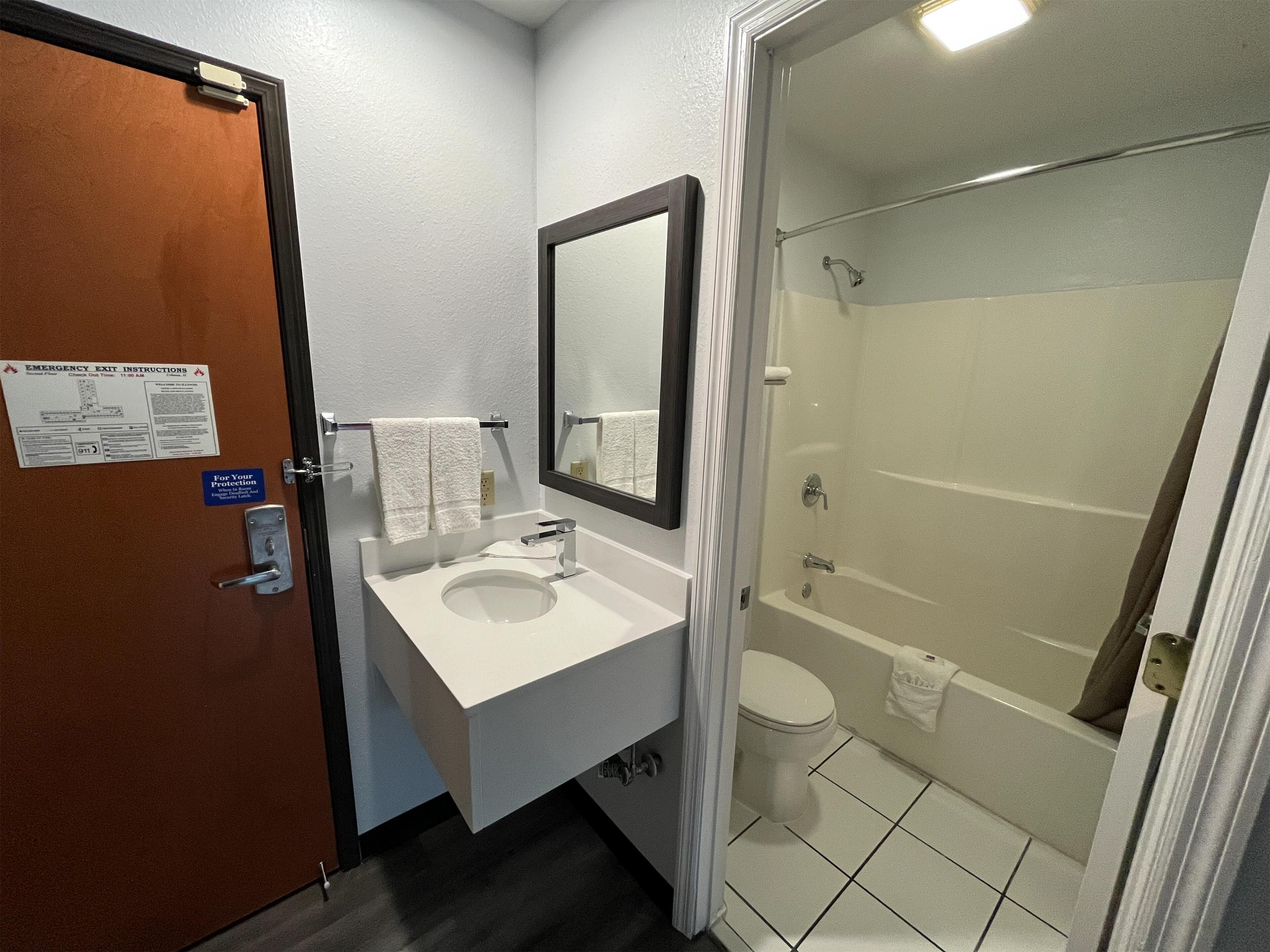 A bathroom with a sink, mirror, toilet, and shower.