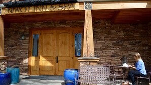 A wooden entrance with a sign reading "Niwot Inn & Spa" and stone walls. - Niwot Inn & Spa (Longmont)