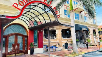 A hotel entrance with a red archway, a covered outdoor seating area, and a visible 'FORTU' sign.