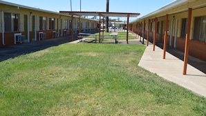 A motel with a central courtyard, outdoor seating, and a covered picnic area. - Gateway Inn (Red Bluff)