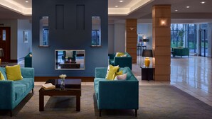 A spacious lobby with teal sofas, a coffee table, and a large mirror. - Radisson Blu Hotel & Spa, Limerick (Cratloe)