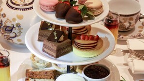 A tiered dessert display with various pastries and a tea set.