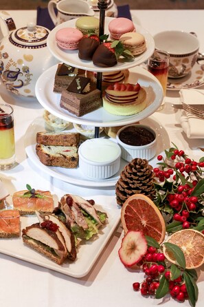 A tiered dessert display with various pastries and a tea set.