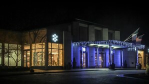 A hotel entrance with illuminated windows and a snowflake sign, featuring a modern architectural style.