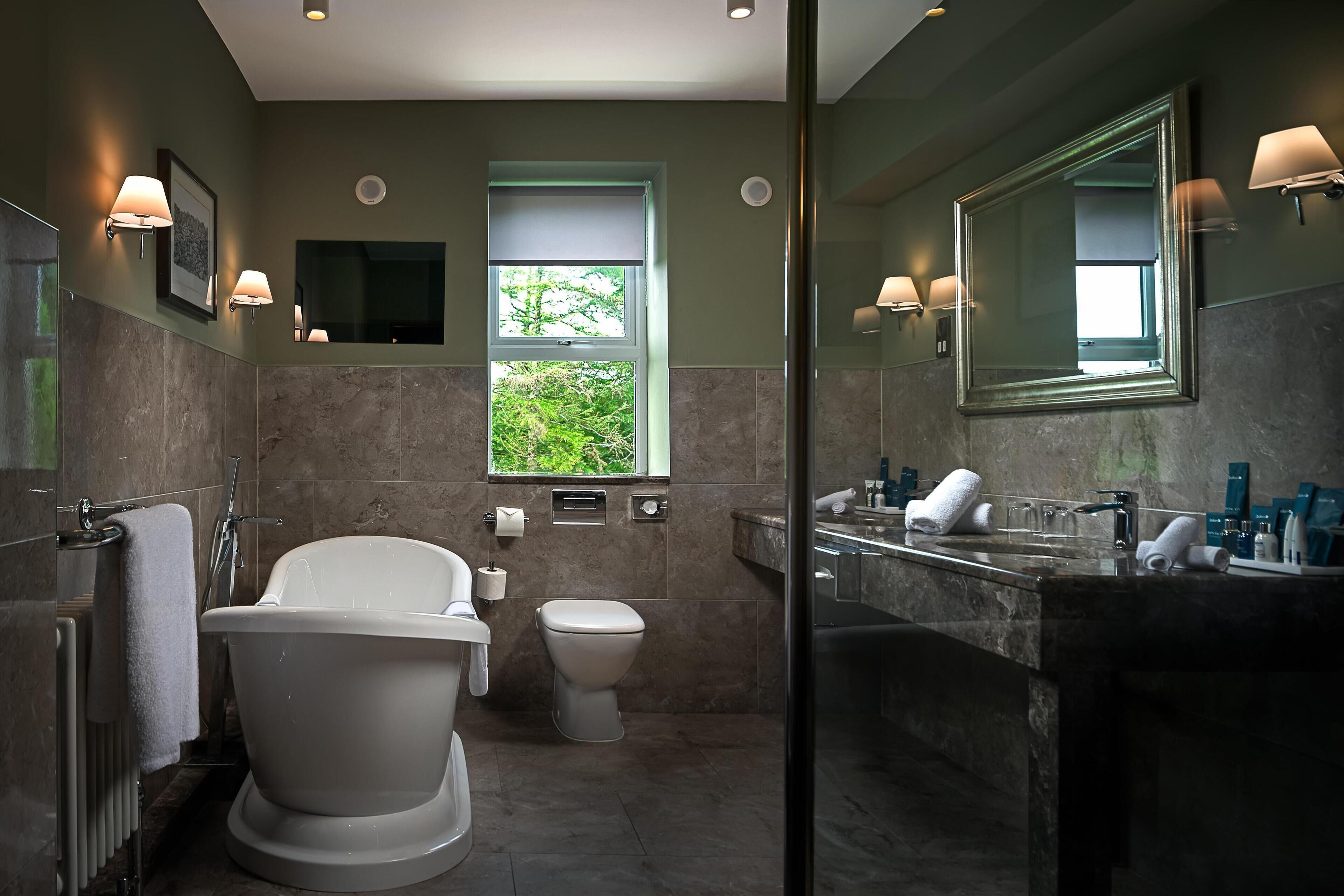 Un baño moderno con bañera, inodoro y tocador.