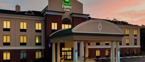 A Holiday Inn Express & Suites hotel with a brick facade, multiple windows, and a covered entrance area.
