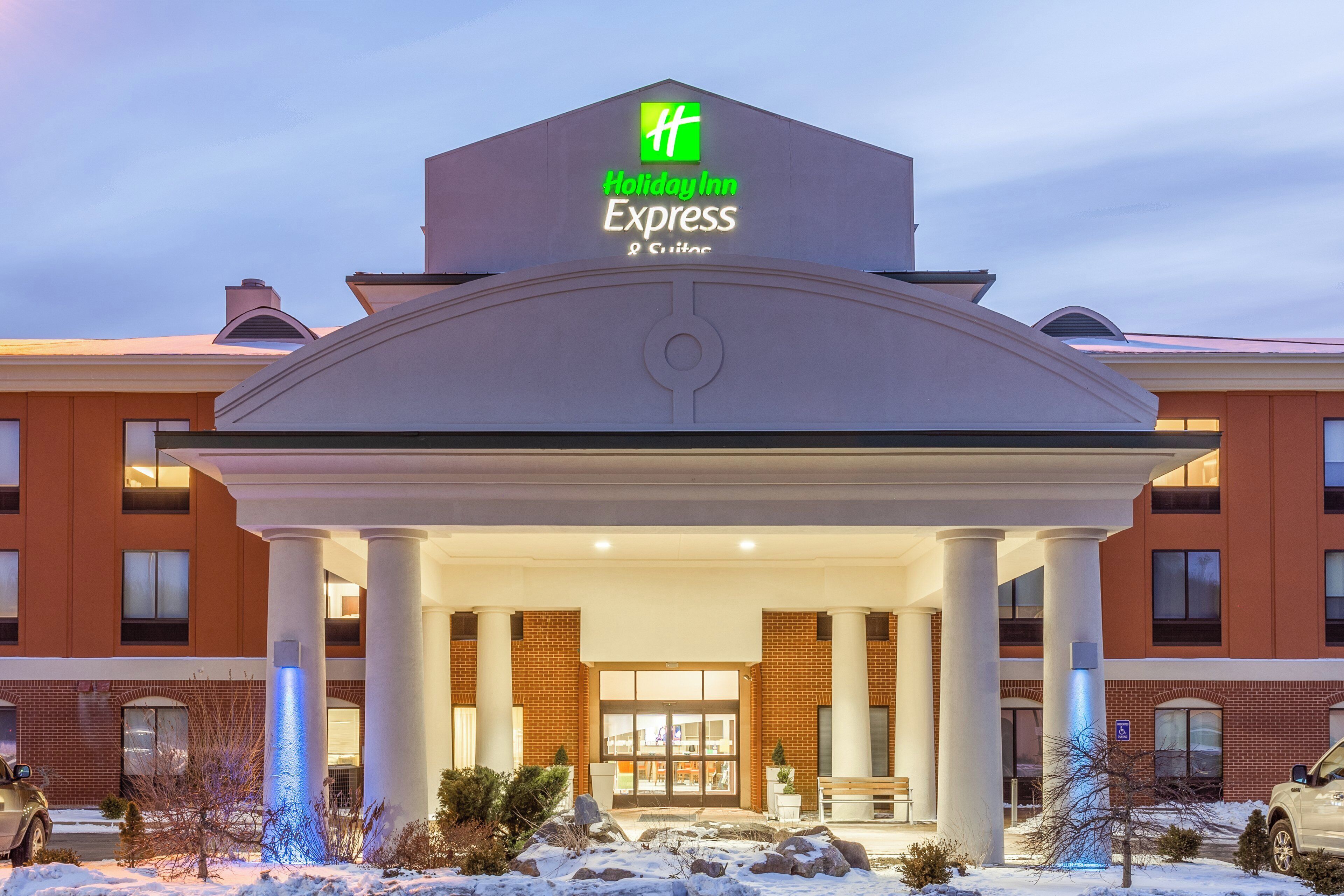 A Holiday Inn Express hotel with a central entrance, brick facade, and snow-covered surroundings.