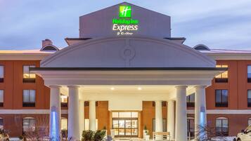 A Holiday Inn Express hotel with a central entrance, brick facade, and snow-covered surroundings.
