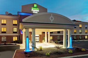 Un Holiday Inn Express & Suites con entrada cubierta, columnas y estacionamiento.