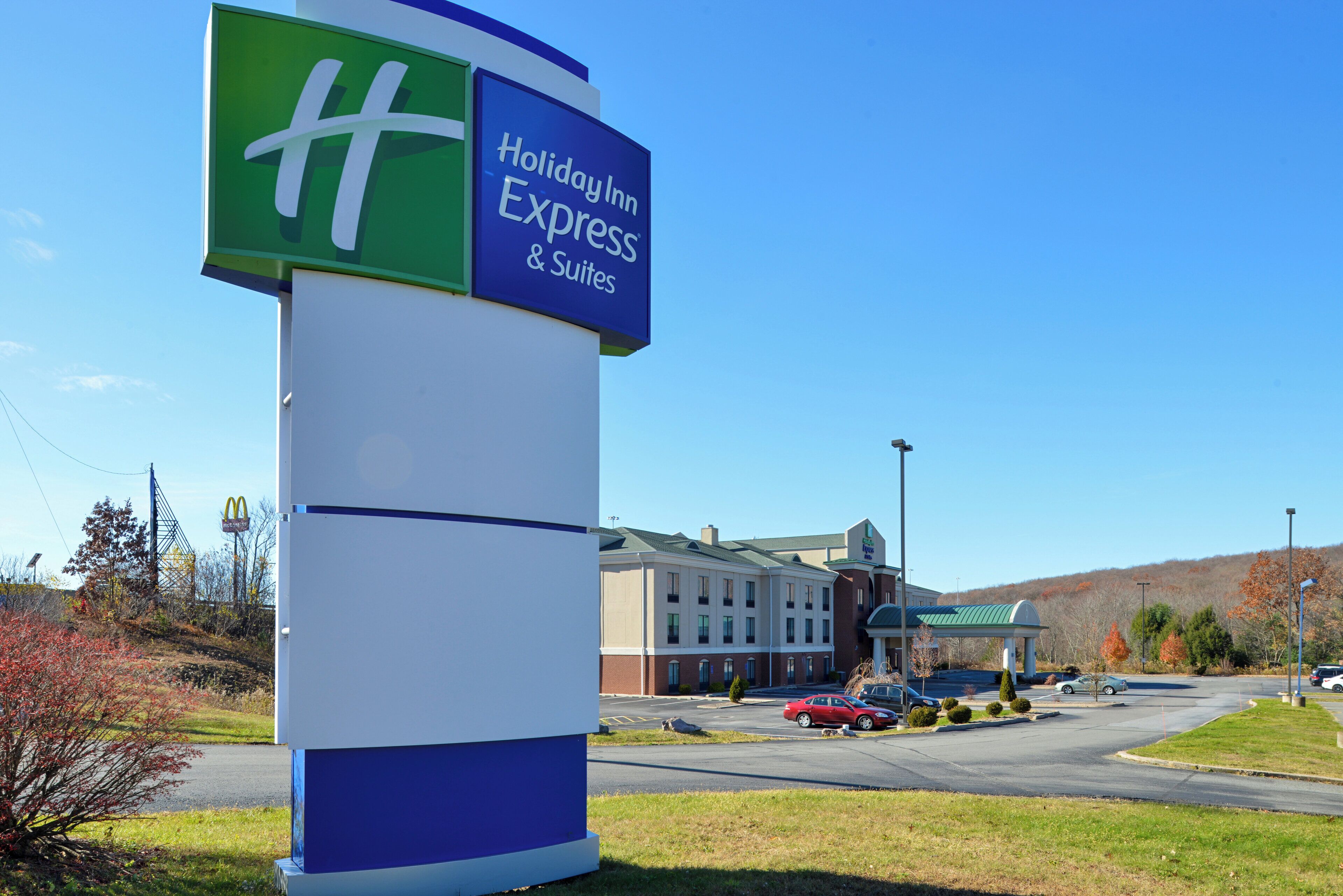 Ein Schild von Holiday Inn Express & Suites, im Hintergrund ist das Hotelgebäude gut sichtbar.