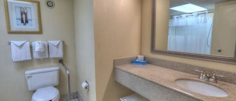 Un baño con inodoro, lavabo y un taburete pequeño.