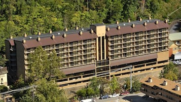 Ein mehrstöckiges Hotel mit einem zentralen Innenhof, umgeben von Bäumen.
