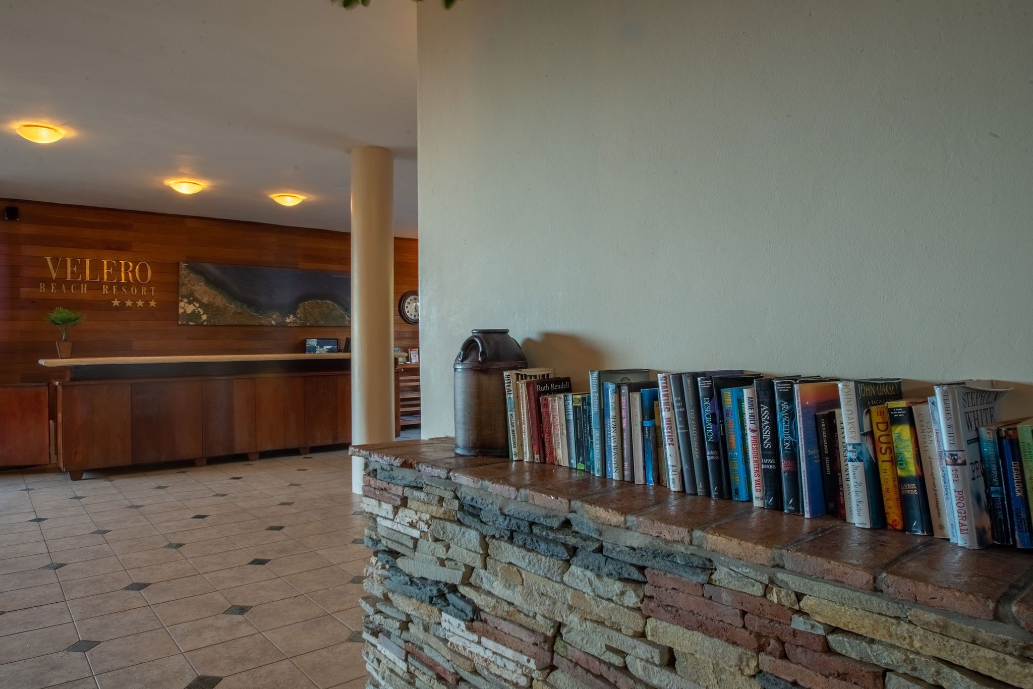 A reception area with a stone counter, a wooden reception desk, and a wall-mounted clock.