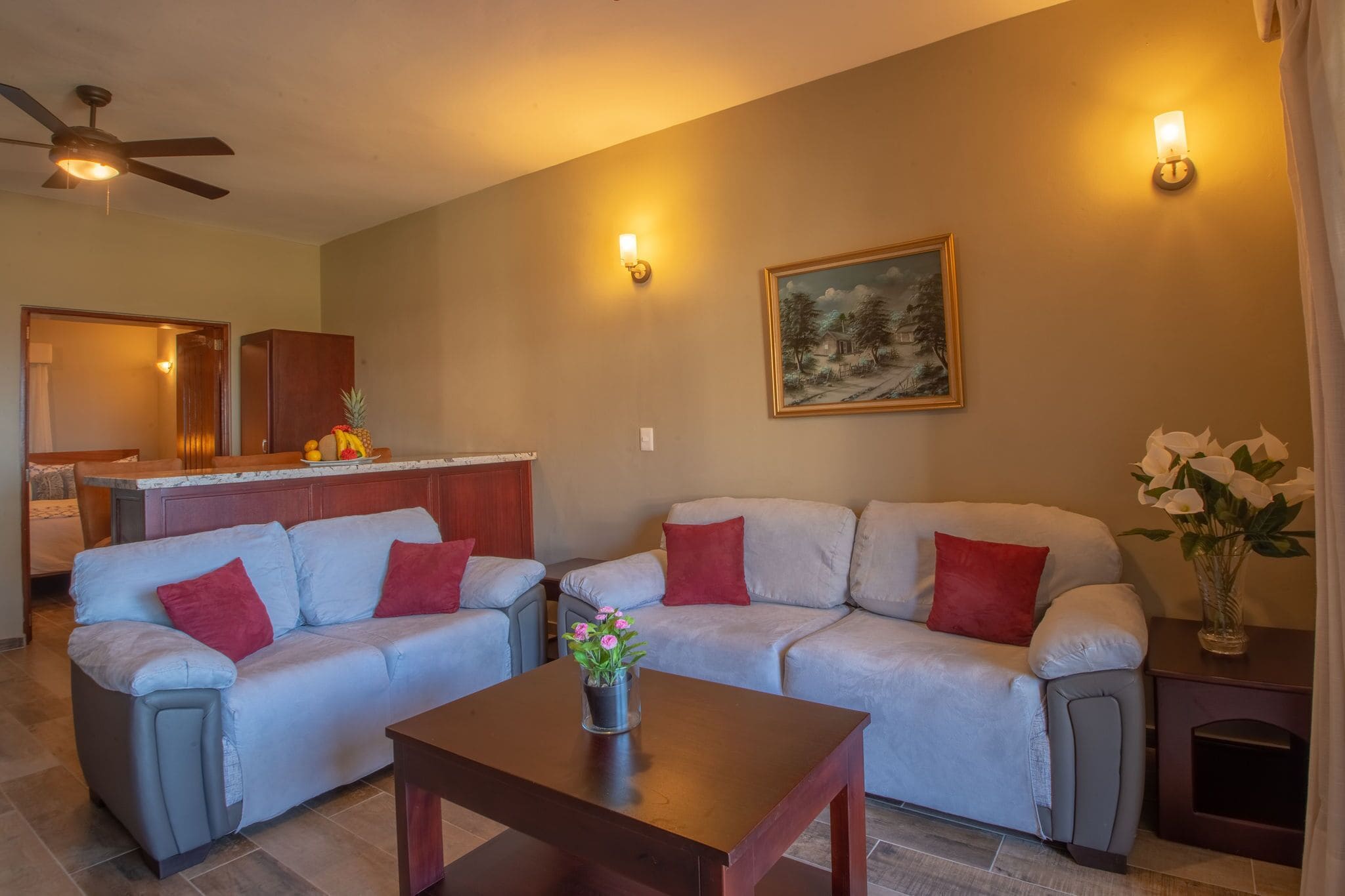 Un salon avec deux canapés, une table basse et un tableau accroché au mur.