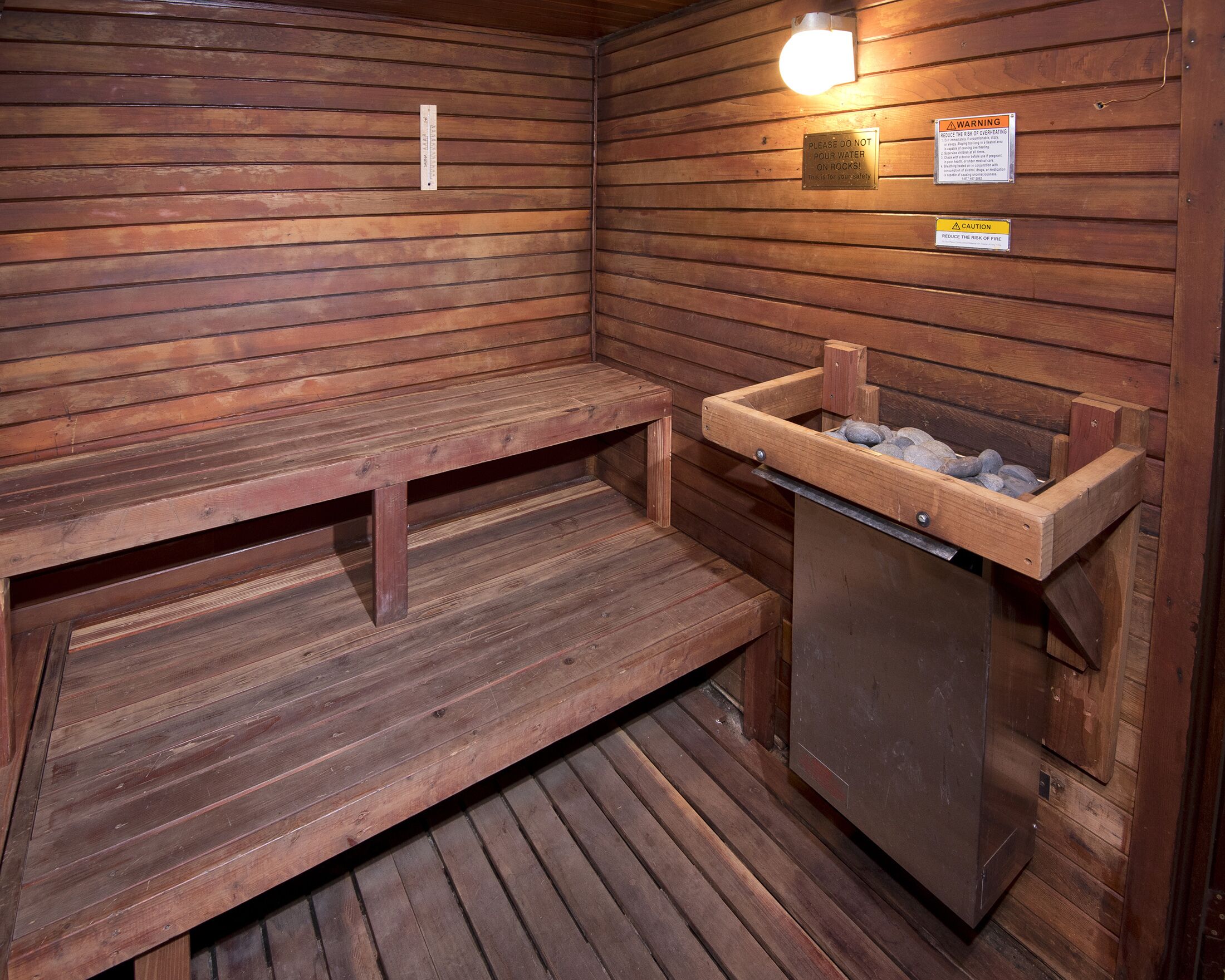 A sauna with wooden benches and a stone basin.