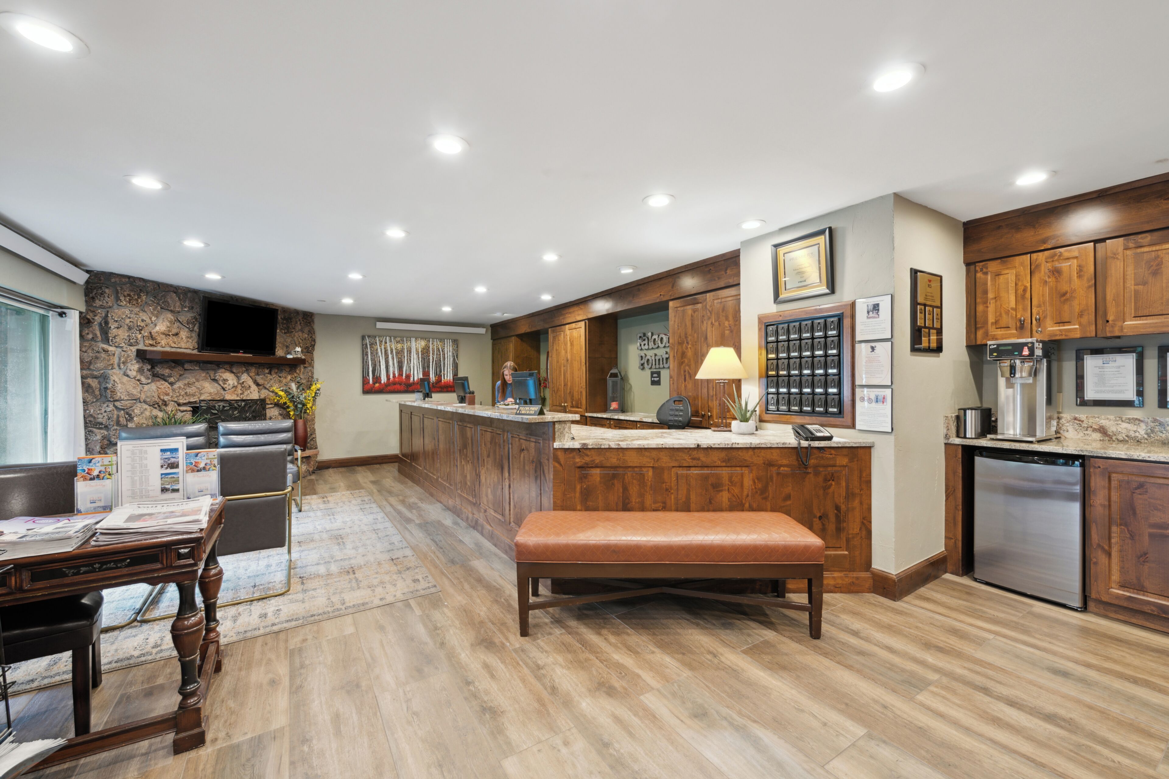 Una cocina moderna con una pared de acento de piedra, armarios de madera y una isla integrada con asientos.