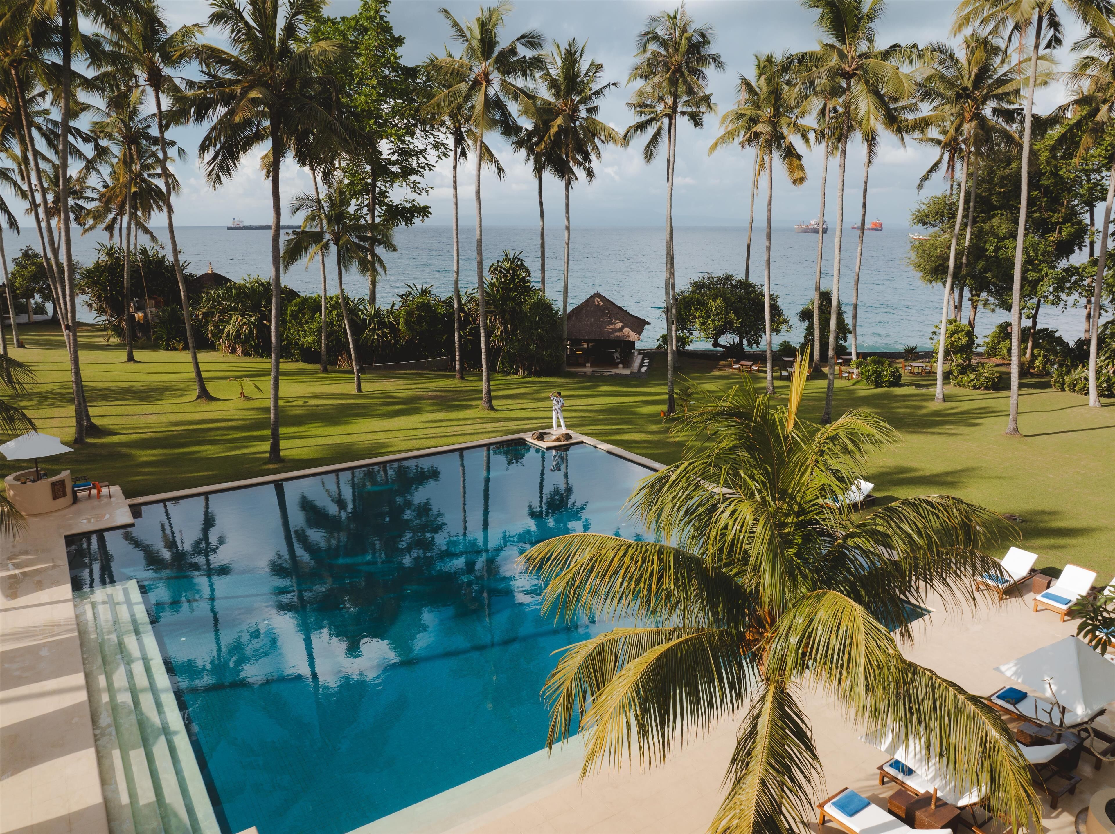 Een buitenzwembad, ligstoelen bij het zwembad